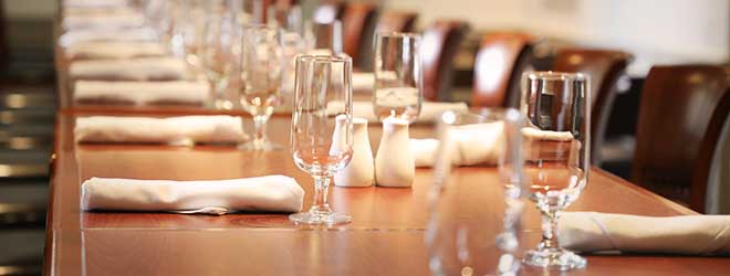 a close-up view of the place settings on a long dining table in the In Camera dining room 