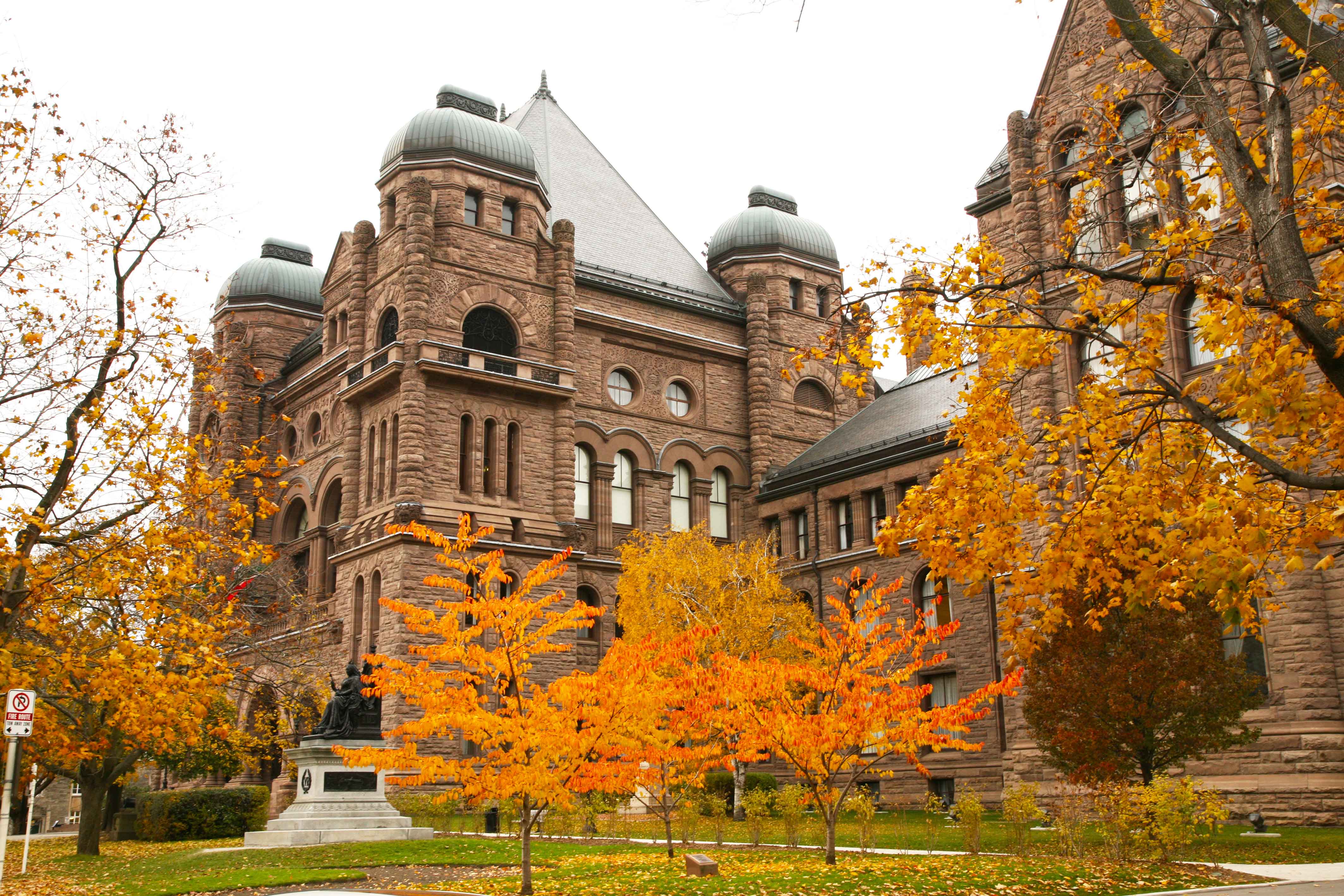 L'extérieur du bâtiment législatif à l'automne, entouré de feuillage orange.