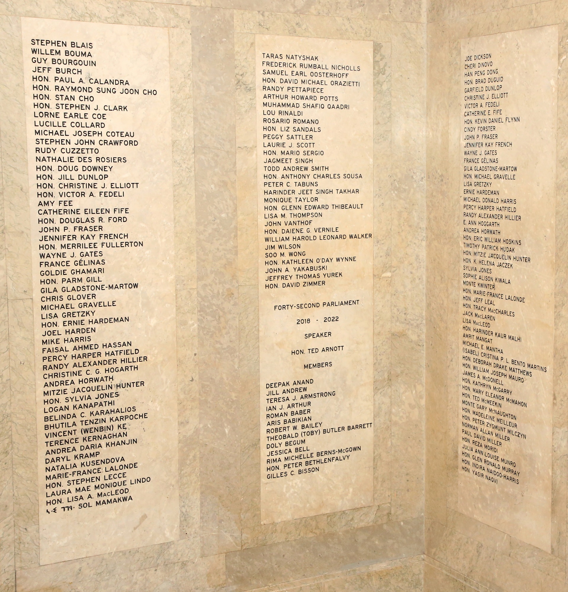 Photo montrant les murs de marbre portant les noms des anciens députées et députés.