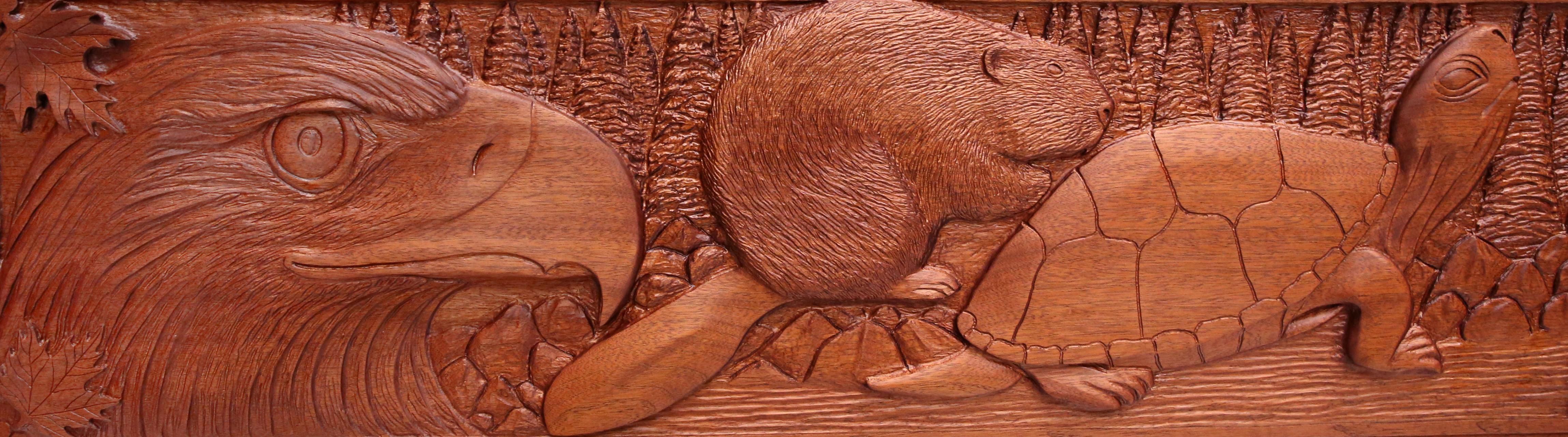 a detail of the Seven grandfather carving showing a bird, a beaver, and a turtle