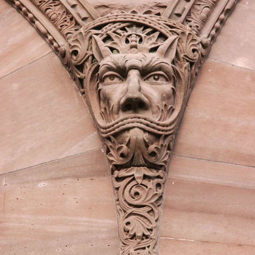 Sculpture en grès d'un visage en forme de gargouille à l'extérieur du bâtiment législatif