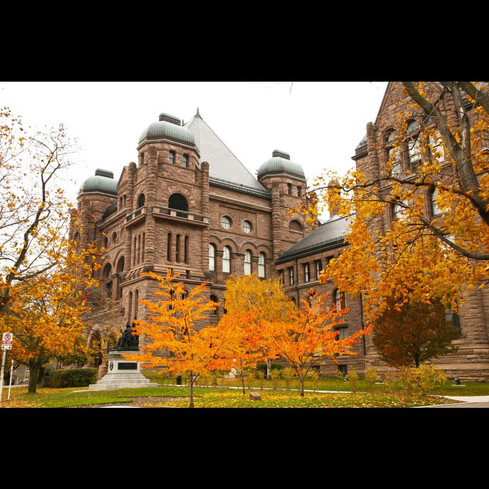 L'extérieur du bâtiment législatif à l'automne, entouré de feuillage orange.