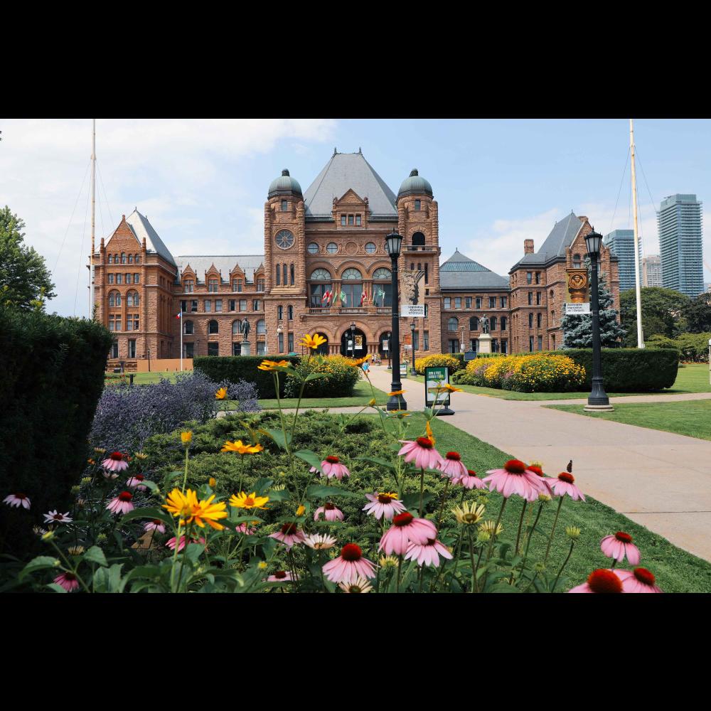 The front of the Legislative building in the summer with multicoloured flowers in the foreground