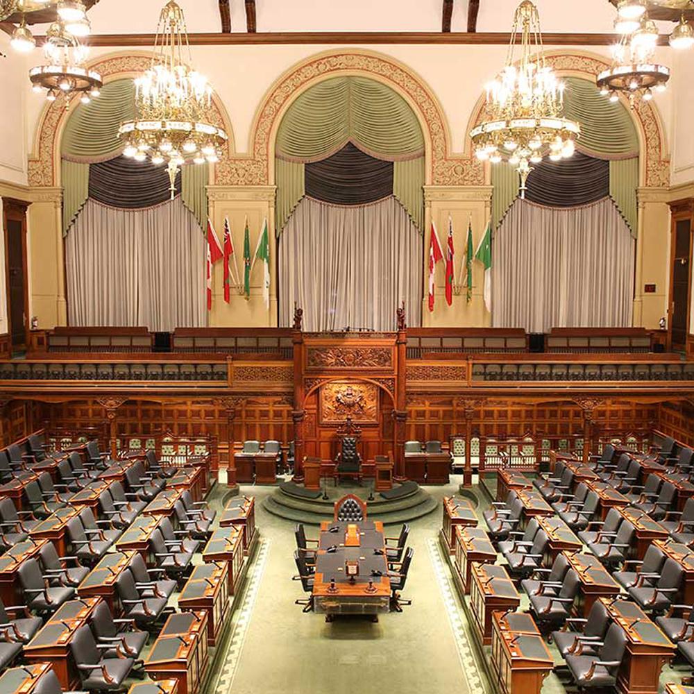 a fulsome view of of the Legislative Chamber depicting the ornate wood carvings featured throughout