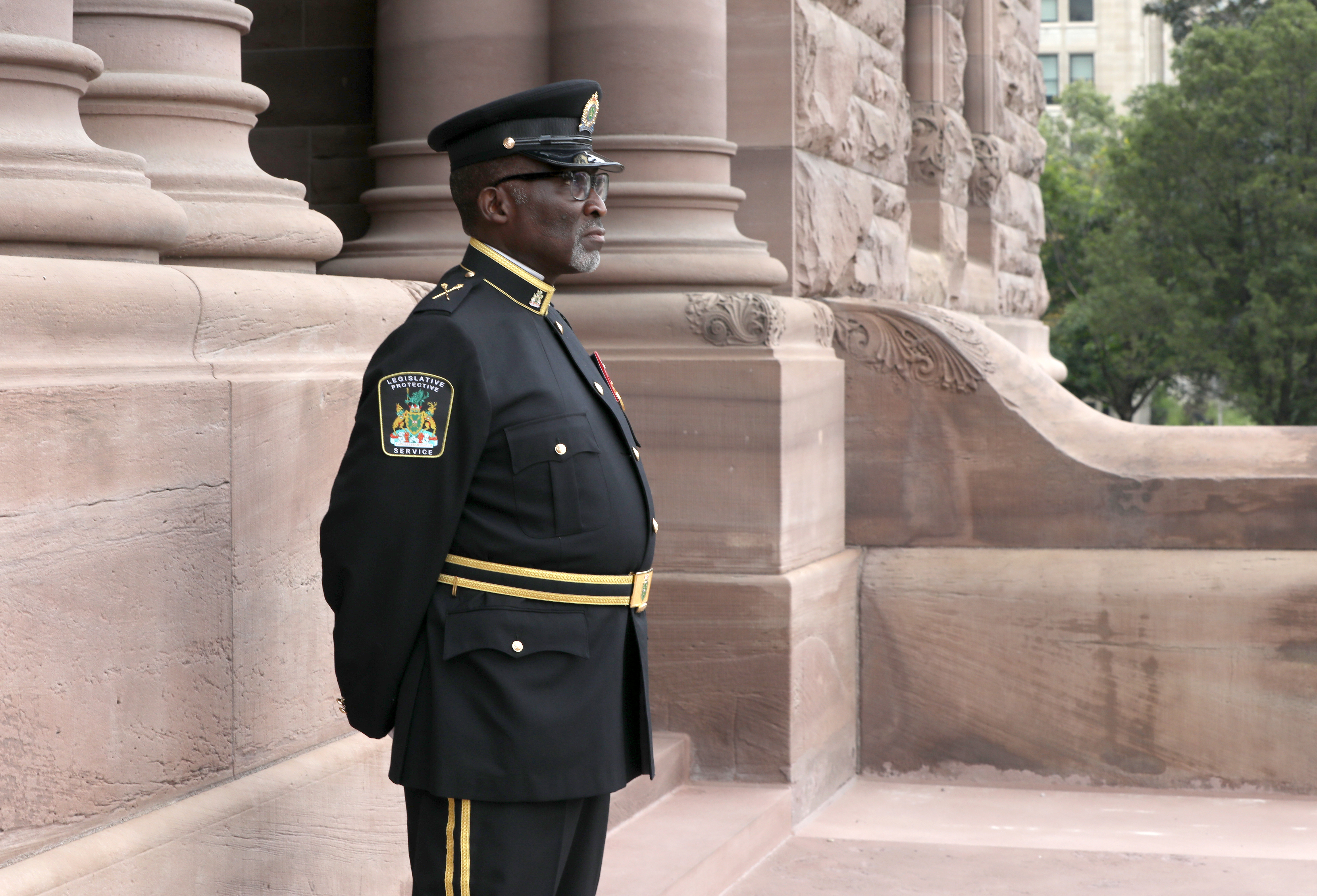 officer standing outside of building in ceremonial uniform