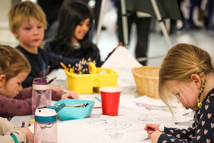 a group of children colouring and drawing at a table