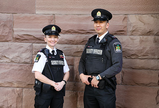 two legislative protective service officers standing in front of building