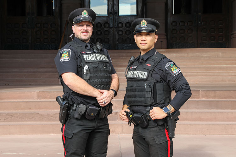 two Legislative Protective Service officers standing outside building