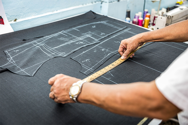 Gros plan sur un tailleur prenant les mesures d'un costume.