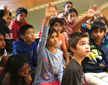 Un groupe d'enfants avec les mains levées