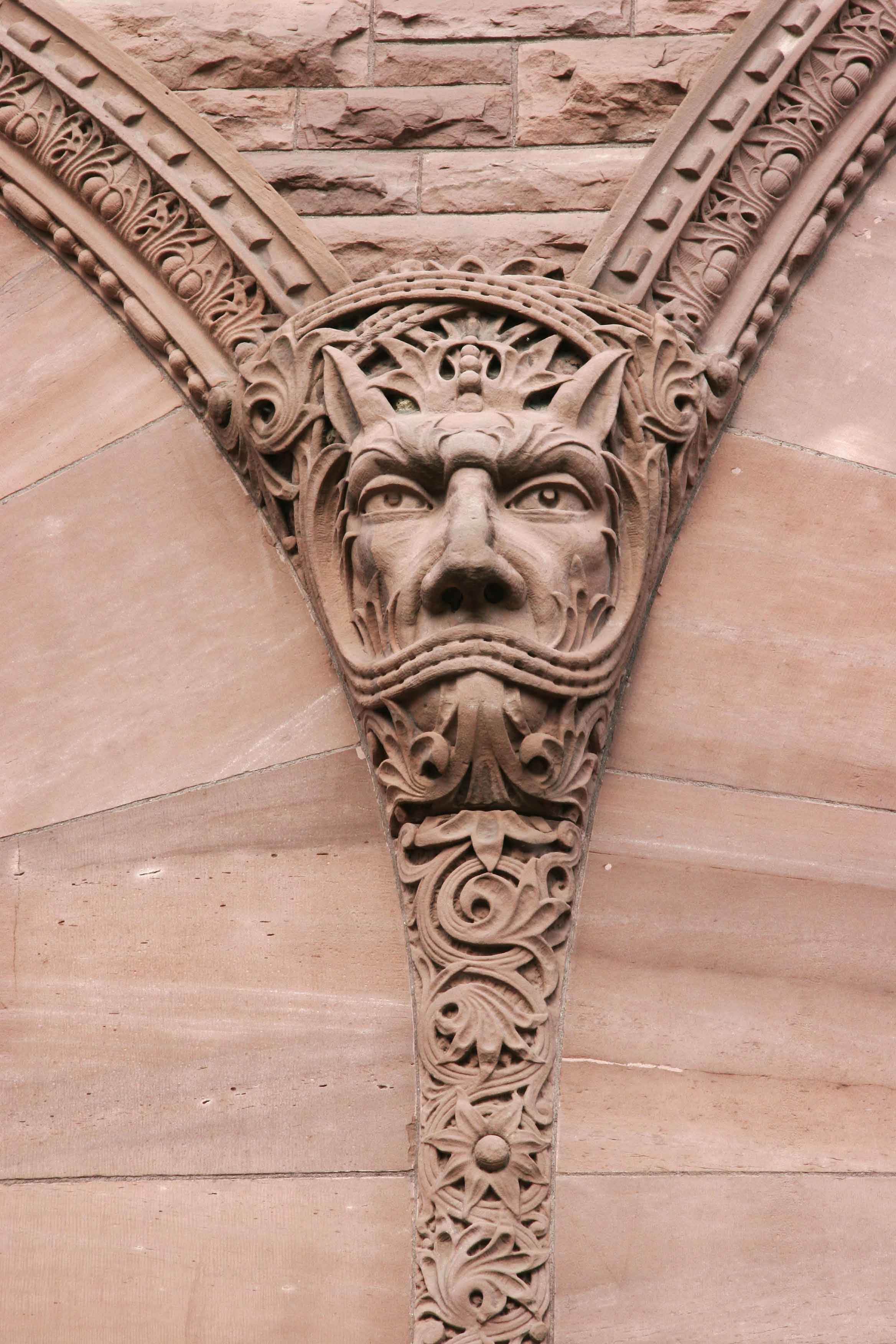 Sandstone carving of a gargoyle-like face on the outside of the Legislative building