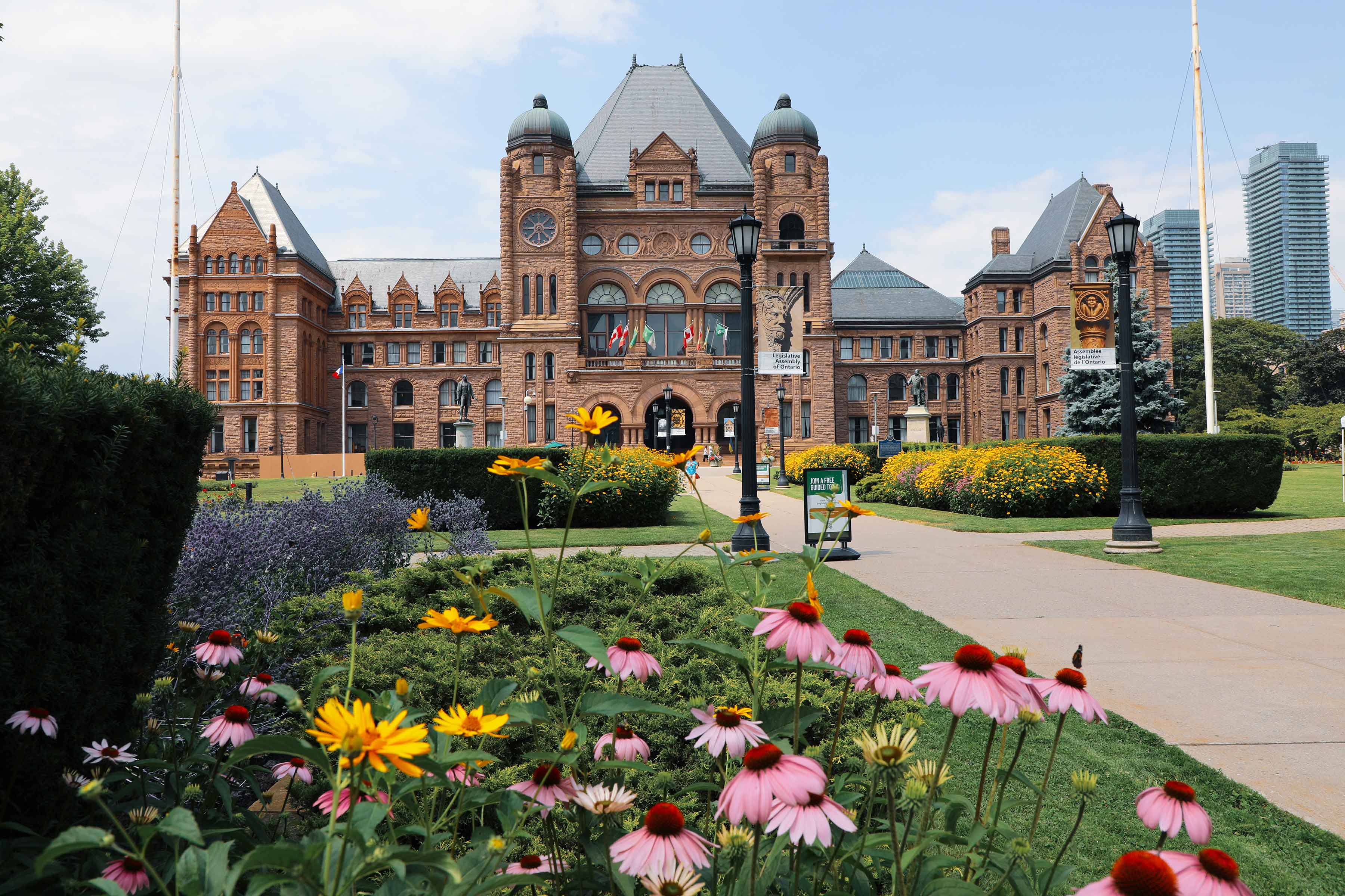 La façade du bâtiment législatif en été avec des fleurs multicolores au premier plan