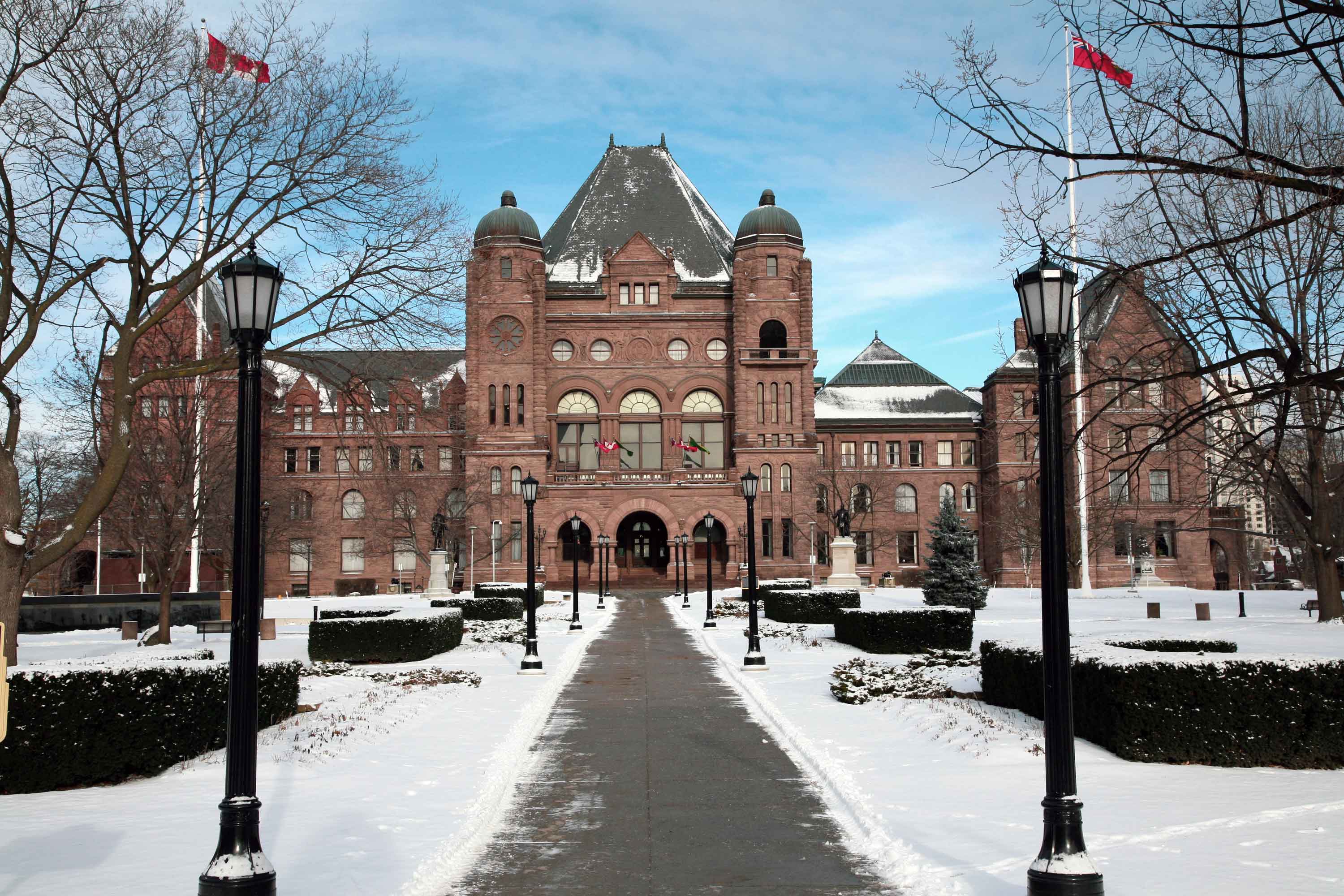 A front view of the Legislative building in winter surrounded by snow.