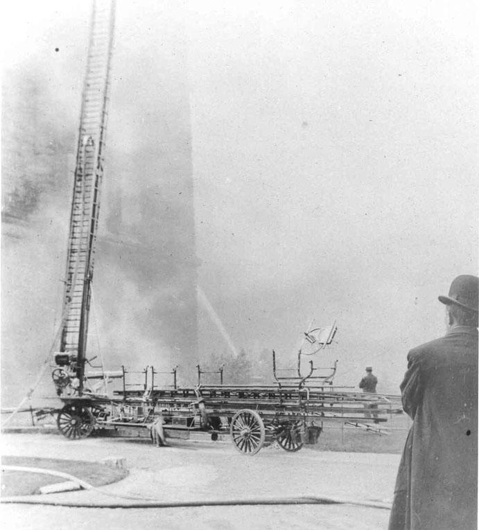 Des pompiers tentent de maîtriser l'incendie de 1909 à l'Assemblée législative