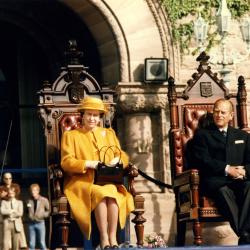 Her Majesty Queen Elizabeth II seated next to His Royal Highness The Duke of Edinburgh during a 1984 visit to Ontario's Legislature.